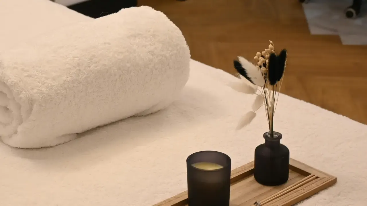 Detalhe do ambiente do Day Spa: toalha, vela acesa e bandeja de cuidados